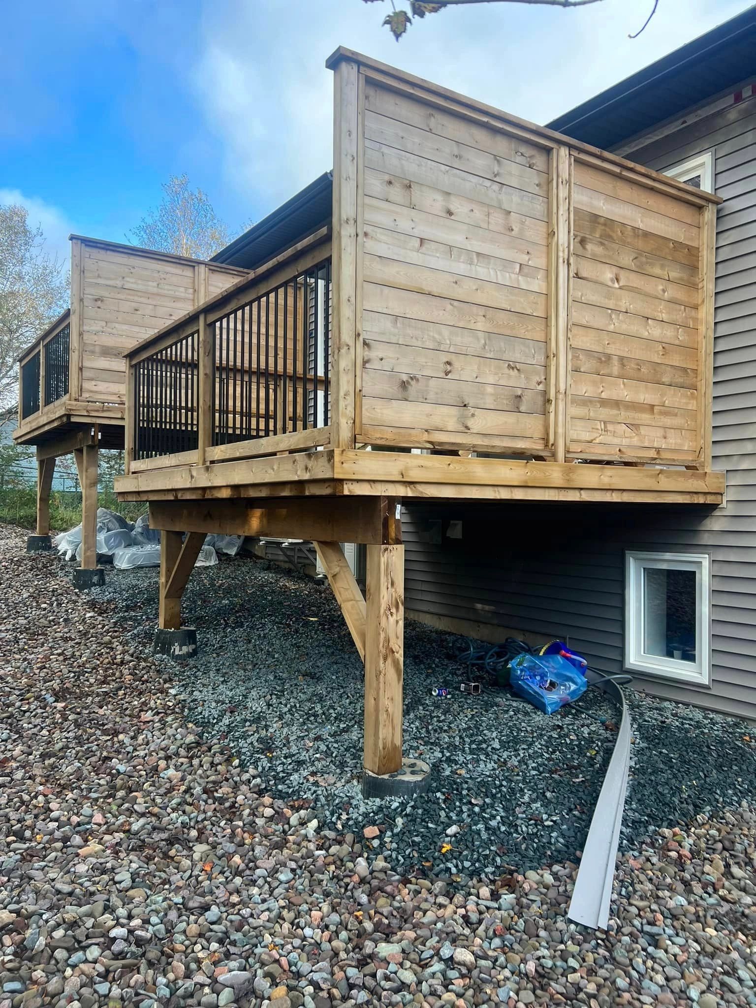 Elevated wooden deck with black railings on residential home